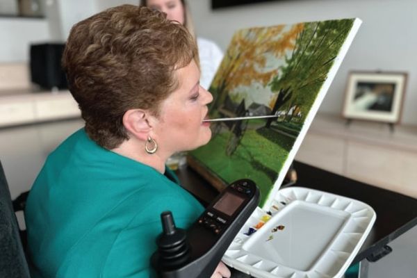 artist susie matthias painting with brush in mouth